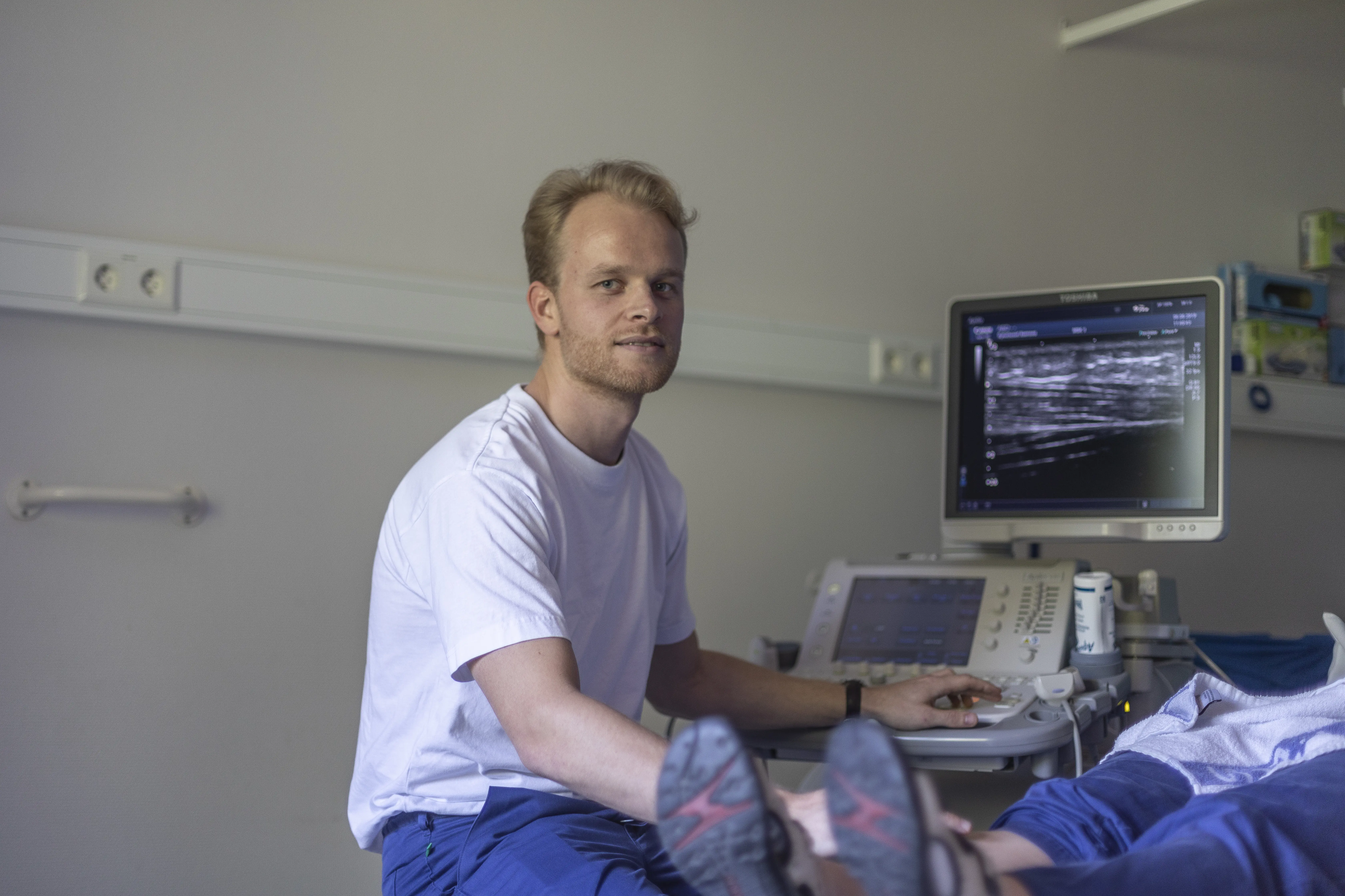 LIS-lege i radiologi undersøker pasient. Foto.