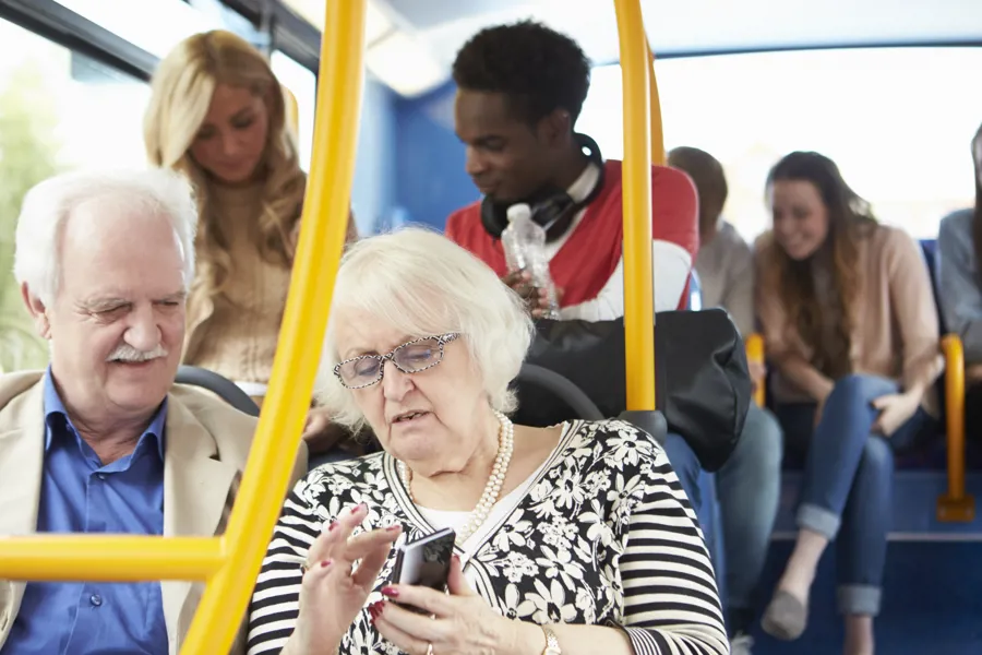 Eldre ektepar sitter på i en buss. Foto.
