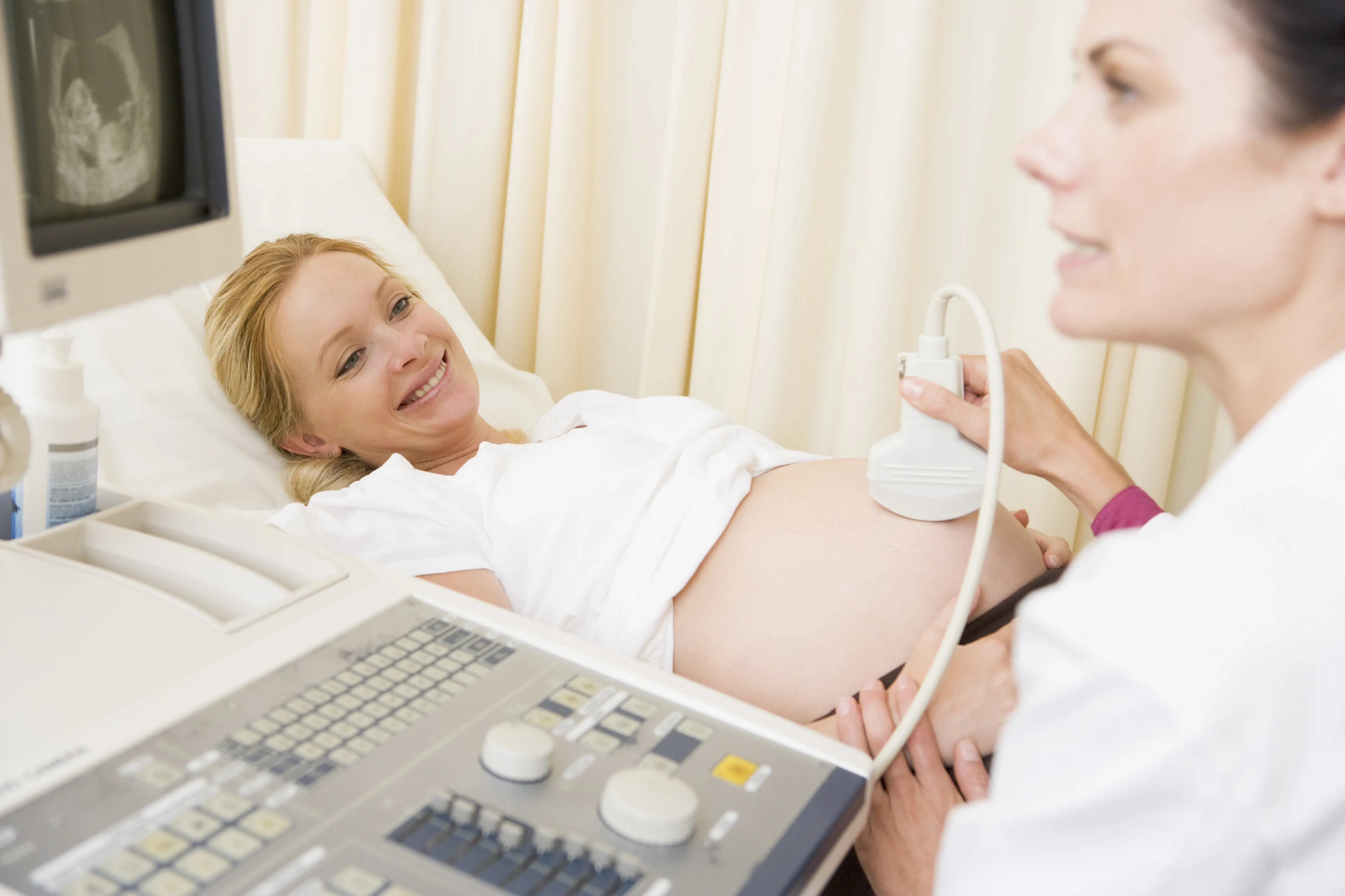 Behandler utfører ultralyd på gravid kvinne. Foto.